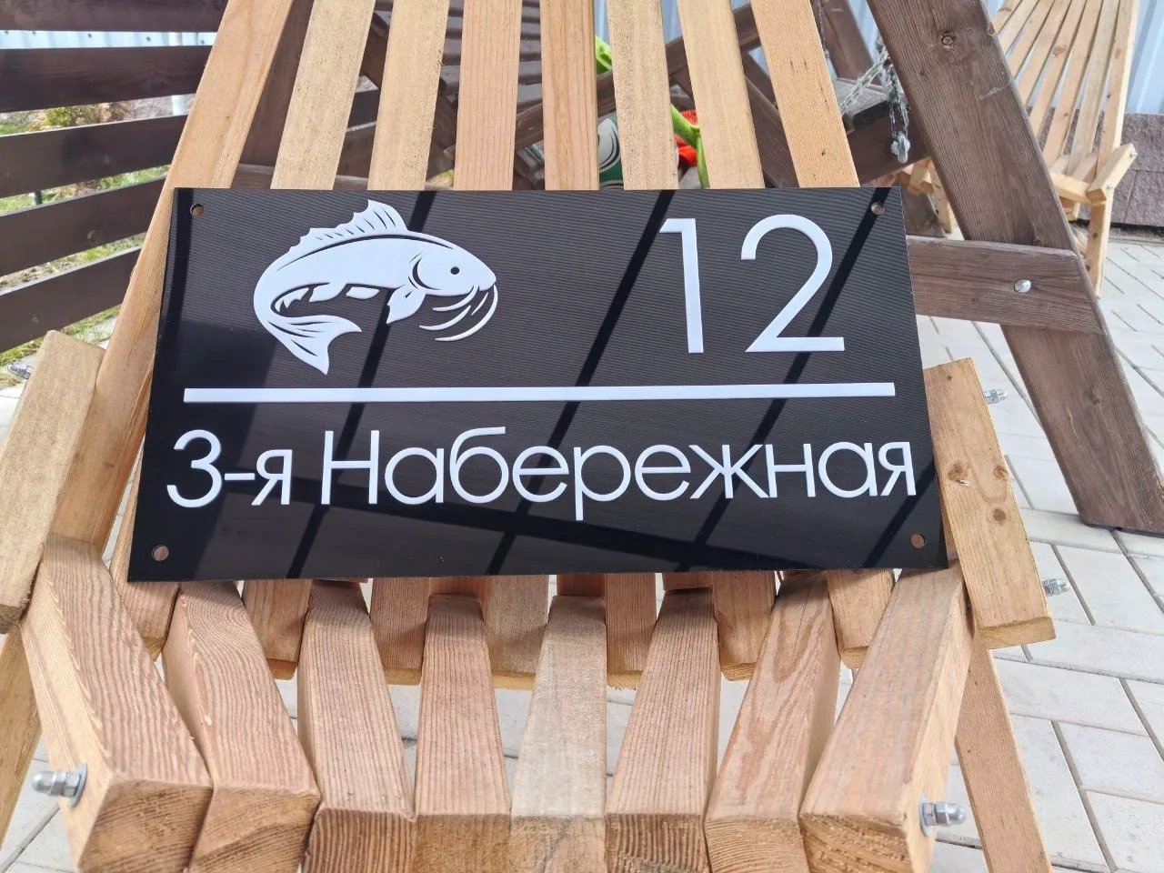 Черная адресная табличка на фасаде дома