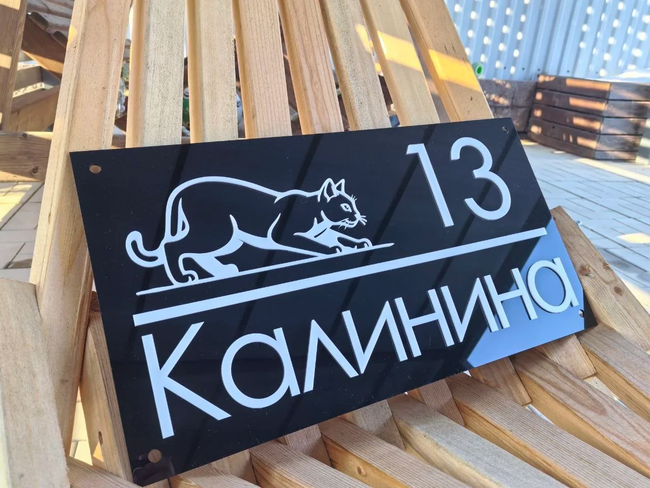 Глянцевая черная адресная табличка с белым номером 13, улицей Калинина и графическим изображением крадущейся кошки