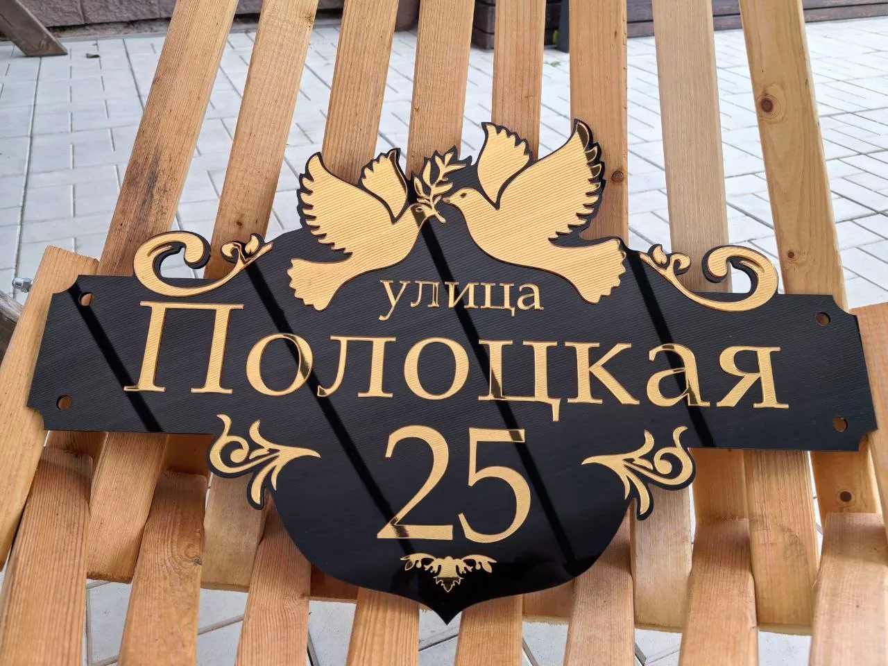 Фигурная черная табличка из акрила с зеркальным золотым номером 25, названием улицы Полоцкая и объемными фигурами летящих голубей