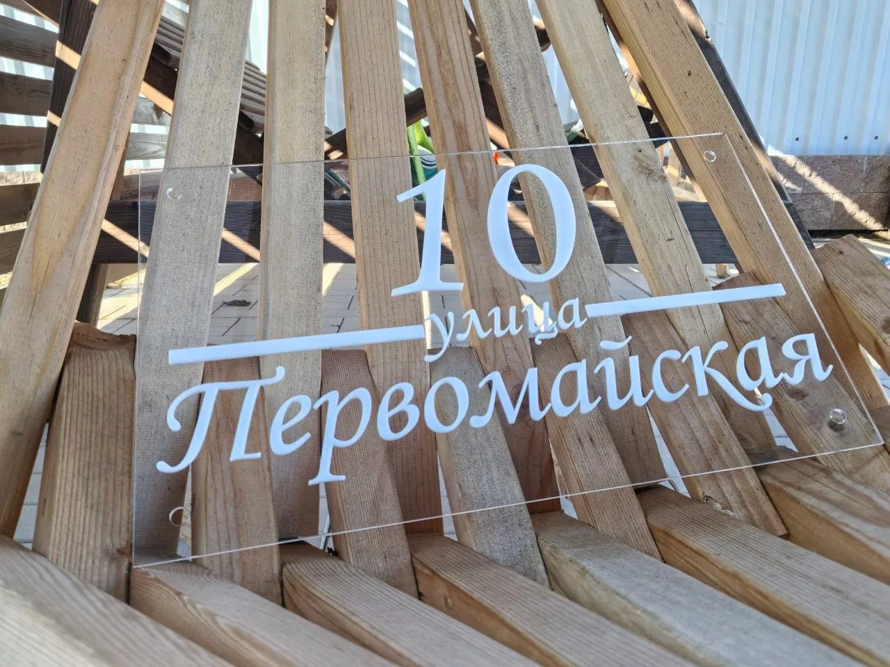 Прозрачная адресная табличка из акрила с белым номером 10 и названием улицы Первомайская, выполненным каллиграфическим шрифтом