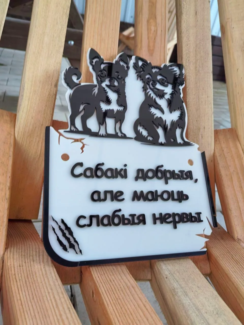 Белая акриловая табличка с объемными черными фигурами двух собак и надписью «Сабакі добрыя, але маюць слабыя нервы»